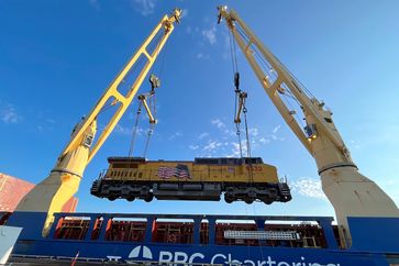 Eine der Lokomotiven wird auf das Schiff nach Peru gehoben.