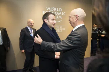 Bild: Klaus Schwab, the chairman of WEF welcomes the french president Emmanuel Macron. Speakers room. Annual Meeting 2018 of the World Economic Forum in Davos. January 24, 2018. Copyright by World Economic Forum / Pierre Abensur / Eigenes Werk