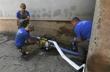 Archivbild: Mitarbeiter russischer Rettungsdienste beim Wegpumpen des Wassers im Gebiet Cherson Bild: Taisija Woronzowa / Sputnik