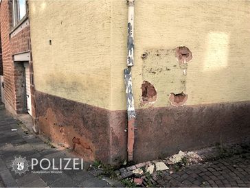 An dieser Hauswand in der Enkenbacher Straße hing der Zigarettenautomat - jetzt sind nur noch die Löcher von der Befestigung zu sehen. Fassade und Dachrinne wurden stark beschädigt. Bild: Polizei