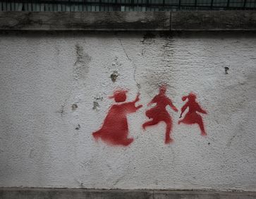 Graffito, welches einen Priester darstellt, der zwei Kindern nachrennt (Symbolbild)