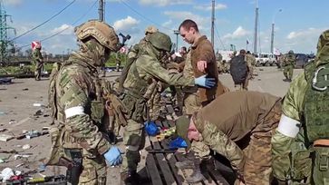 Archivbild: Russische Armeeangehörige durchsuchen ukrainische Soldaten, die sich nach den erbitterten Kämpfen im Hüttenwerk Asow-Stahl in Mariupol ergeben haben, 20. Mai 2022. Bild: VERTEIDIGUNGSMINISTERIUM DER RUSSISCHEN FÖDERATION / Sputnik