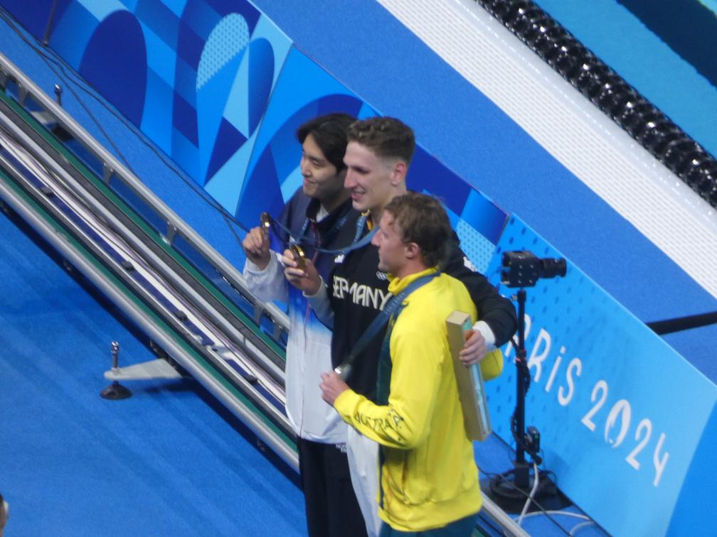 Lukas Märtens (Mitte) nach dem Gewinn der Goldmedaille über 400 Meter Freistil in Paris 2024