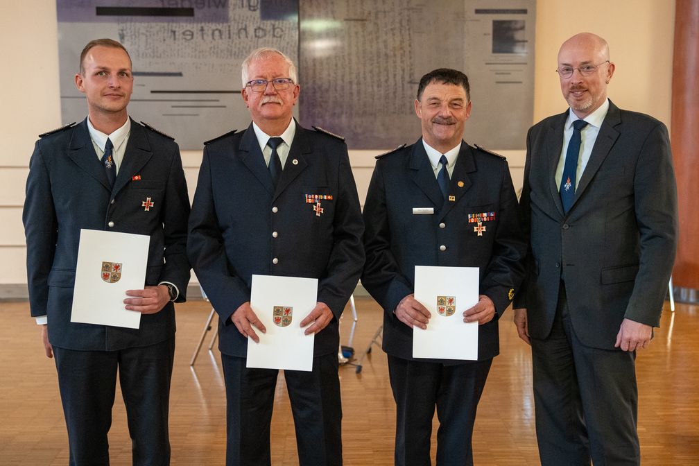 Innenminister Christian Pegel (r.) hat Brandmeister Michael Rühmling, Amtsbrandmeister Jürgen Gäth und Amtsbrandmeister Dirk Staudte (v.l.) (2024) Bild: IM