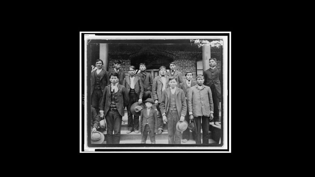 Männer und ein Schüler vor der Carlisle Indian School, ca. 1890 Bild: Library of Congress