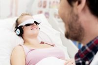 Patientin mit Videobrille von HappyMed - Bild: "obs/Asklepios Kliniken/HappyMed"